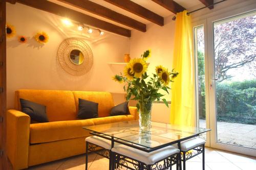 a living room with a yellow couch and a glass table at Lou Cigalou - Au Calme - Grand Jardin - Piscine Partagée - Parking - Campagne et Idéalement Situé Proche A7 et Montélimar in Sauzet