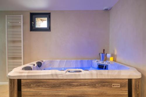 a large blue tub in a room with at La Grange Clyna - Love Room in Parigné-lʼÉvêque