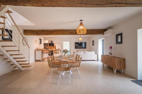 a dining room and living room with a table and chairs at La Grange Clyna - Love Room in Parigné-lʼÉvêque