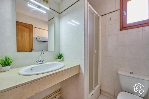 une salle de bain avec un lavabo, des toilettes et un miroir dans l'établissement Piso con vistas Saillagouse, à Saillagouse