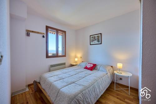 une chambre avec un lit avec un oreiller rouge dessus dans l'établissement Piso con vistas Saillagouse, à Saillagouse