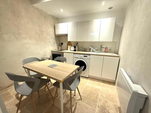 une cuisine avec une table, des chaises et un évier dans l'établissement Maison des berges, à Arles