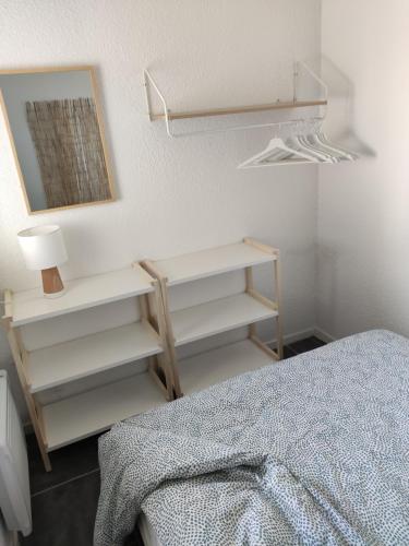 - une chambre avec des étagères blanches et un lit dans l'établissement Appartement rénové au Penon, à Seignosse