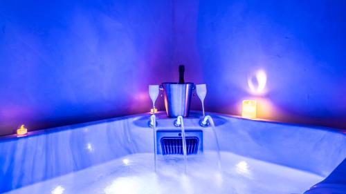 a table with a candle and two lights on it at La Grange Clyna - Love Room in Parigné-lʼÉvêque