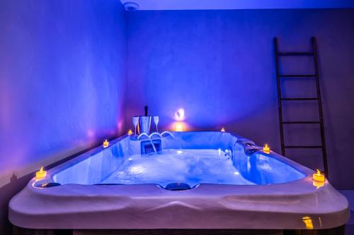 a blue room with a bath tub with lights at La Grange Clyna - Love Room in Parigné-lʼÉvêque