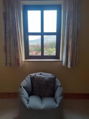 a chair in a room with a window at Nature's Edge in Moneyduff