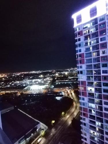 a night view of a tall building at i-Duplex 1M2R2B Condo - LED Garden, Fun Fair, Waterpark, Wax Museum, Mall & More! in Shah Alam