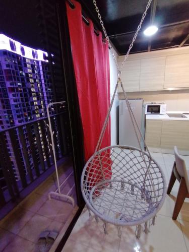 a hanging chair in a room with a kitchen at i-Duplex 1M2R2B Condo - LED Garden, Fun Fair, Waterpark, Wax Museum, Mall & More! in Shah Alam