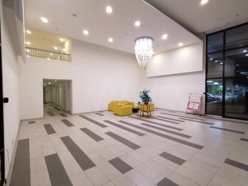 a lobby with a yellow couch and a chandelier at i-Duplex 1M2R2B Condo - LED Garden, Fun Fair, Waterpark, Wax Museum, Mall & More! in Shah Alam