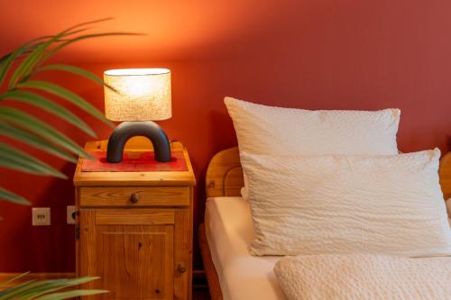 a bedroom with a bed and a lamp on a night stand at Apartments Bauer in Grafing
