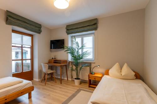 a bedroom with two beds and a desk and a window at Apartments Bauer in Grafing