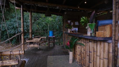 a porch of a cabin with a table and chairs at YAY Sustainable in Guachaca