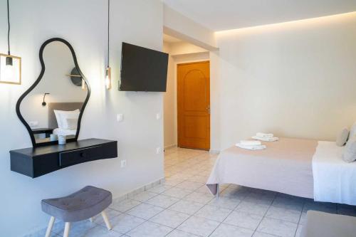 a bedroom with a bed and a mirror and a chair at Avenue Hotel Falassarna in Falasarna