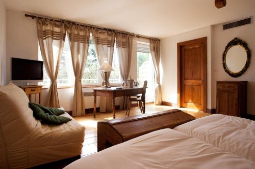 a bedroom with a desk and a couch and a table at Le Domaine de Rouffach in Rouffach