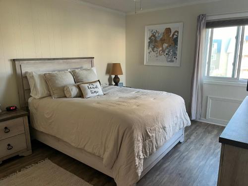 マートルビーチにあるSalt Lifeのベッドルーム1室(大型ベッド1台、枕付)、窓が備わります。