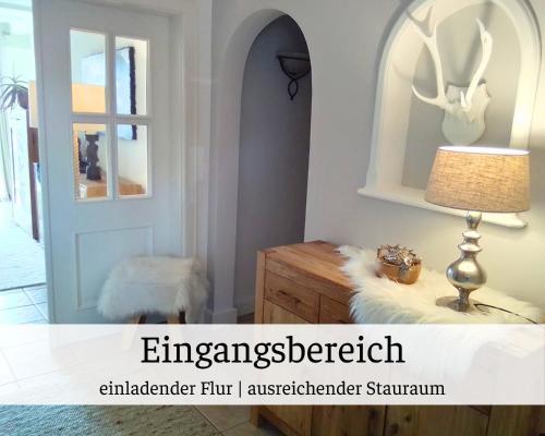 a room with a table with a lamp and a mirror at Ferienhaus Waldblick Heimbuchenthal - mit Kamin, Wintergarten und Terrasse in Heimbuchenthal