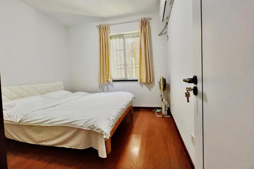 a small bedroom with a bed and a window at Nicer Family in Leshan