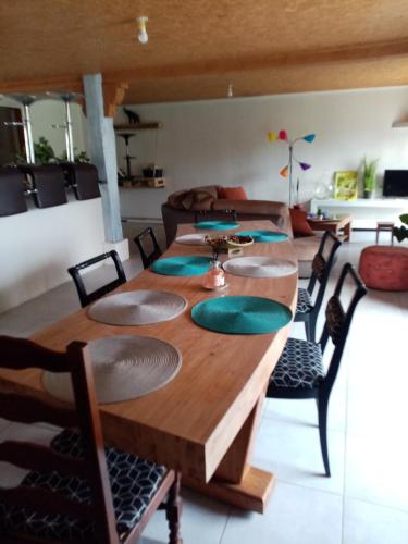 une salle à manger avec une longue table en bois et des chaises dans l'établissement Lepetibonheur47, à Razimet