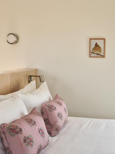 a bedroom with a bed with pink pillows at The Martinsburg in Stonewall