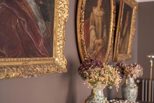 a painting and a vase with flowers on a table at les Myrrhophores et Spa, Chambres d'Hôtes et Gîtes de charme in Abbeville