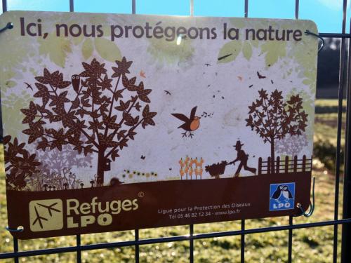 a sign on a fence with a picture of trees at Maison Super Calme et Confortable - Idéalement Située - Clim - Vue Montagnes - Piscine Partagée - Parking Gratuit - Lou Tranquillou in Sauzet