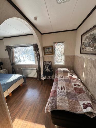 a bedroom with a bed and an arched window at Cottage Viardo in Vehkataipale