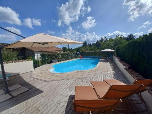 une piscine avec des chaises et un parasol dans l'établissement Gites Champfort, à Saint-Vallier
