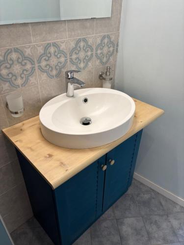 a bathroom with a white sink and blue cabinets at Appartamento Casa Fontana Asti in Asti