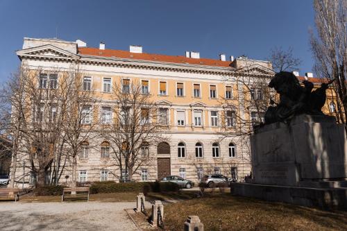 a statue in front of a large building at Lion Loft in Sopron