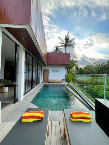a villa with a swimming pool and a house at Puri Gia in Mambat