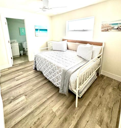 a bedroom with a bed with a wooden floor at Sunny Shores Retreat 6 in Clearwater Beach