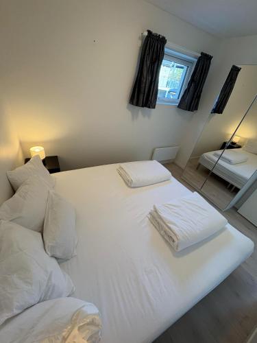 a white bed with two towels on top of it at Lisas apartment, private new 1 bedroom and 1 living room with sofa bed and big windows, share with nobody in Oslo