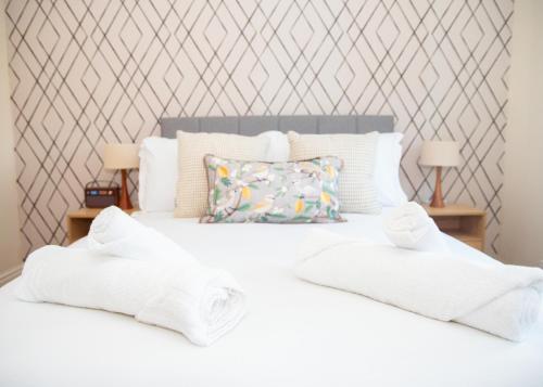 a bedroom with a white bed with two white towels at 4x Bed Elegant Home with Parking in Ely