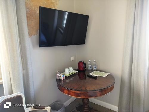 a small table with a television on a wall at B&B Suite 44 in Pesaro