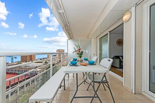 une table blanche et des chaises sur un balcon avec vue dans l'établissement VILLA FLORENTINE III - Somptueux deux pièces MONACO - Vue mer - Parking, à Beausoleil