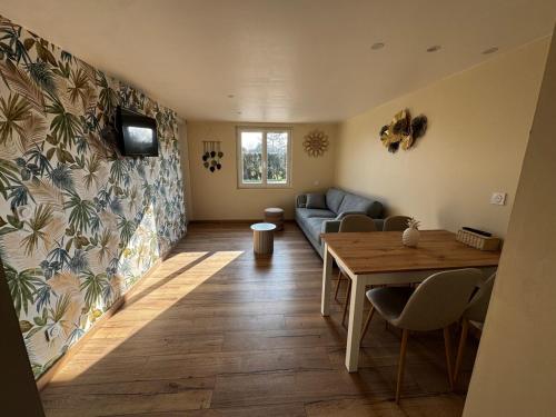 un salon avec un canapé et une table dans l'établissement Gîte au cœur de la nature, à Fresnoy-Folny
