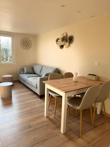 un salon avec une table et un canapé dans l'établissement Gîte au cœur de la nature, à Fresnoy-Folny
