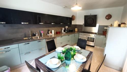 - une cuisine avec une table et des bouteilles dans l'établissement Maison de bourg magique de 1860, à Loguivy-Plougras