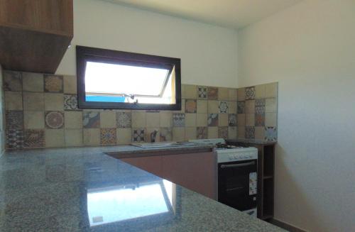 a kitchen with a window and a sink and a stove at Duplex Frente mar in Playa Dorada