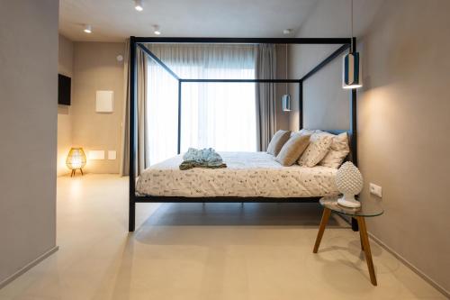 a bedroom with a black canopy bed with a window at Oikos Rooms in Marsala
