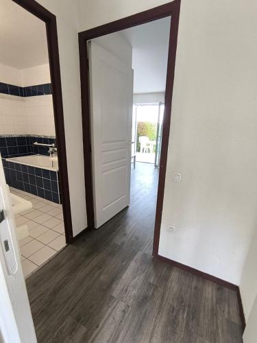 un couloir avec une porte menant à une salle de bains. dans l'établissement residence cap ocean ARZON, à Arzon