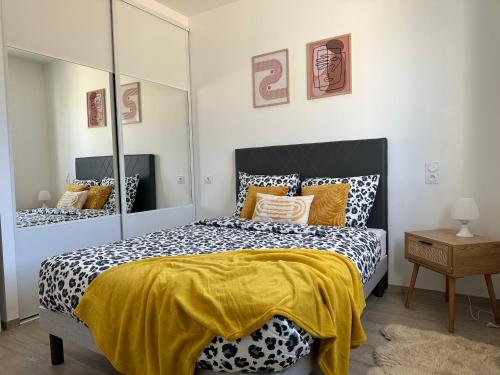 une chambre avec un lit noir et blanc avec une couverture jaune dans l'établissement Dépendance maisonnette paisible piscine privee, à Bias