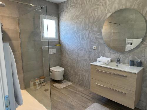 une salle de bain avec une douche, un lavabo et un miroir dans l'établissement Dépendance maisonnette paisible piscine privee, à Bias