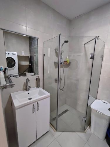 a bathroom with a shower and a sink and a toilet at Bright large apartment in White Sails in Batumi