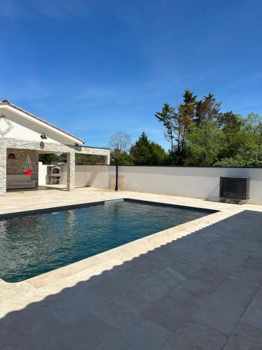 une piscine dans l'arrière-cour d'une maison dans l'établissement Dépendance maisonnette paisible piscine privee, à Bias