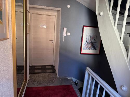 a hallway with a stairway with a blue wall at M & E Ferienwohnung in Bad Mergentheim