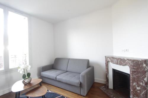 un salon avec un canapé et une cheminée dans l'établissement La plaine de Villemoisson, à Villemoisson-sur-Orge
