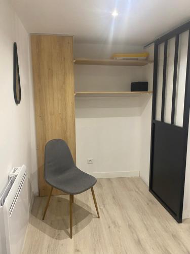 une chaise assise dans une pièce avec placard dans l'établissement Petit nid au centre historique de Marvejols, à Marvejols