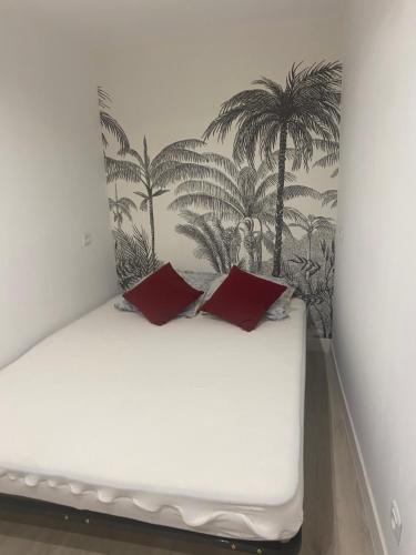 - un lit avec 2 oreillers rouges dans l'établissement Petit nid au centre historique de Marvejols, à Marvejols