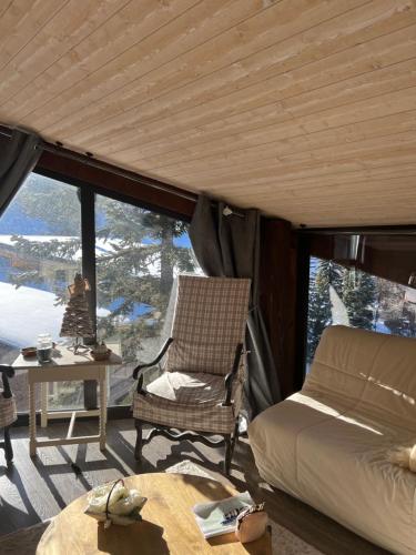 une chambre avec un lit, une chaise et une table dans l'établissement Appartement de montagne, CHARME et calme au pied des pistes, à Enchastrayes